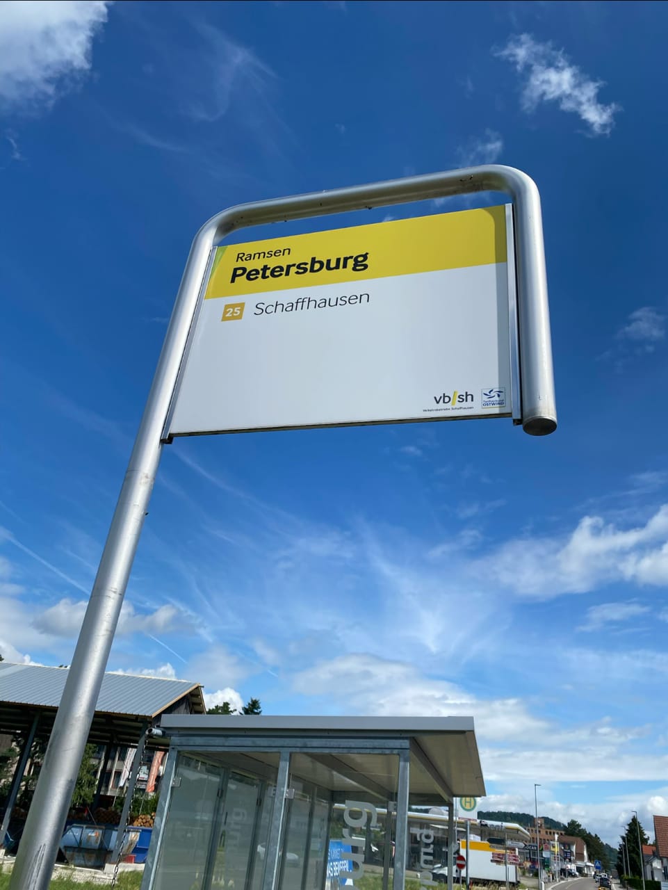 Gelbes Haltestellenschild «Ramsen Petersburg» der Linie 25 nach Schaffhausen vor blauem Himmel